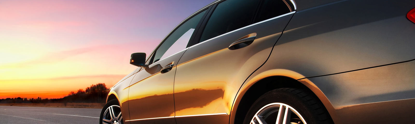 car driving down road at sunset